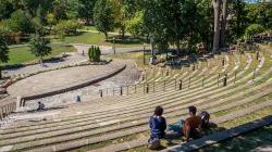 Photo of students sitting in outdoor amphitheater.