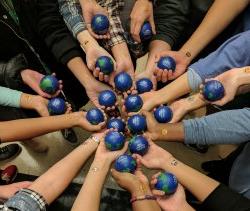 Multiple hands coming into the center holding stress balls