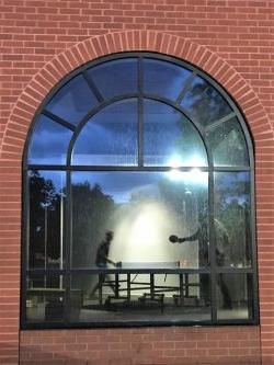 View through window of two people playing table tennis