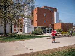 A student walking by one of the buildings on campus.
