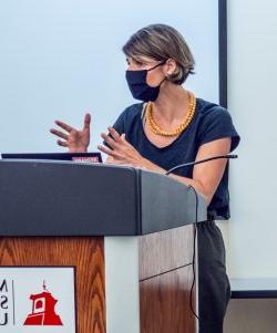 masked female faculty lecturing