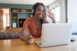 非裔美国妇女在家工作. 向笔记本电脑挥手