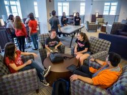 Students sitting around a Residence Hall common area hanging out.
