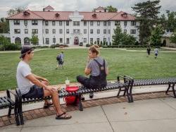 Two students sitting near the Freeman/Russ Quad enjoying a nice day.