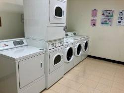 村公寓的洗衣区有洗衣机和烘干机.