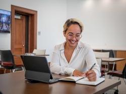 一位文科学士学生在虚拟咨询预约中微笑着工作