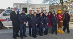 Picture of EMS members and Dr. Susan A. Cole in front of a new ambulance dedicated in the fall '17 semester.